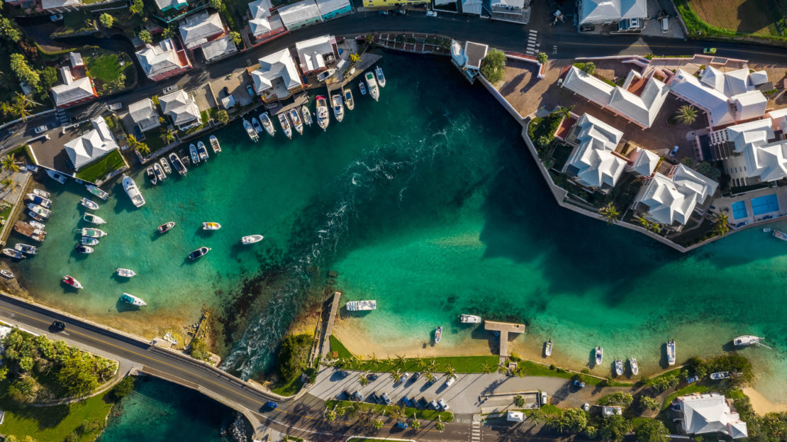 Aerial view of Bermuda houses and businesses along water with boats
