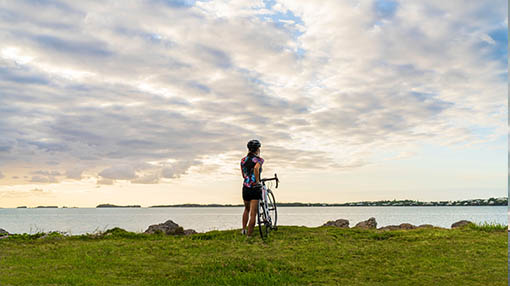 A woman overlooking the ocean after a bike ride